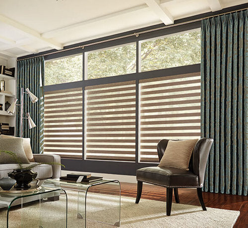 a living room filled with furniture and a window covered in blinds
